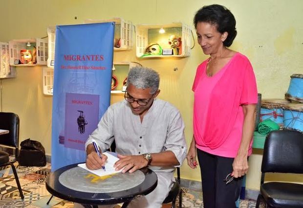 Husmell Díaz Sánchez firma un ejemplar de su libro a Onildia Molinete.