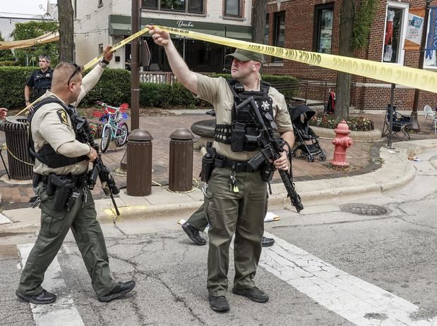 Un par de agentes policiales fue registrado este lunes al inspeccionar la escena de un tiroteo masivo, durante un desfile del 4 de julio, en Highland Park, Illinois, EE.UU.