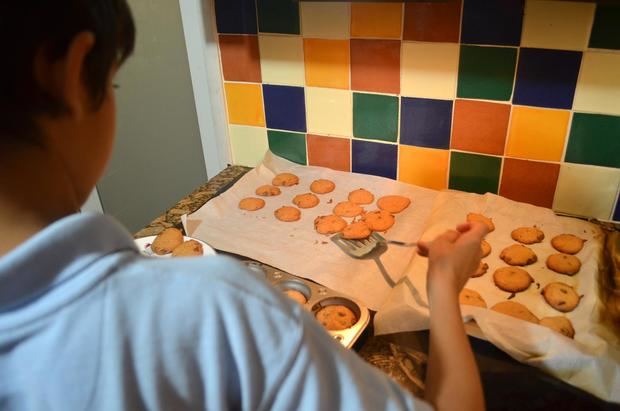 Un niño dispone unas galletas caseras de Navidad en una bandeja, este viernes, en su casa en Miami, Florida.