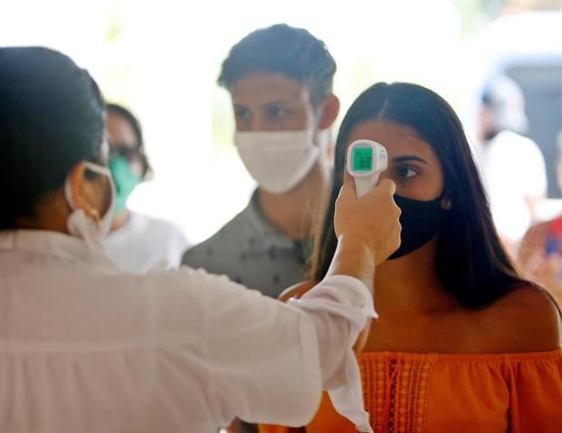 Una trabajadora de la salud toma la temperatura a los visitantes en de Varadero (Cuba). 