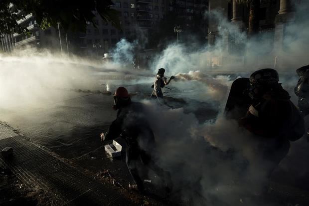 Fuerzas Especiales de Carabineros intentan dispersar a manifestantes que se tomaron la Alameda, principal avenida en Santiago, en Chile.