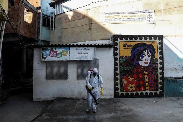 Residentes de la favela Dona Marta, locación que sirvió de escenario para uno de los videos que hizo el cantante Michael Jackson, en Río de Janeiro (Brasil), trabajan en la limpieza de las áreas de la comunidad para evitar que la falta de condiciones sanitarias facilite la propagación del coronavirus. 