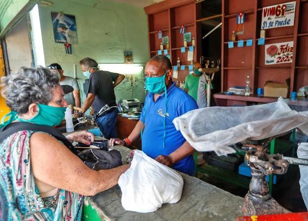 Vendedores y clientes usan tapaboca para protegerse del coronavirus en una tienda estatal de productos variados este jueves, en La Habana, Cuba.