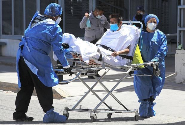 Paramédicos trasladan a un paciente en camilla afectado por covid-19 hoy, del Hospital General a un nosocomio privado, en Ciudad Juárez, estado de Chihuahua.