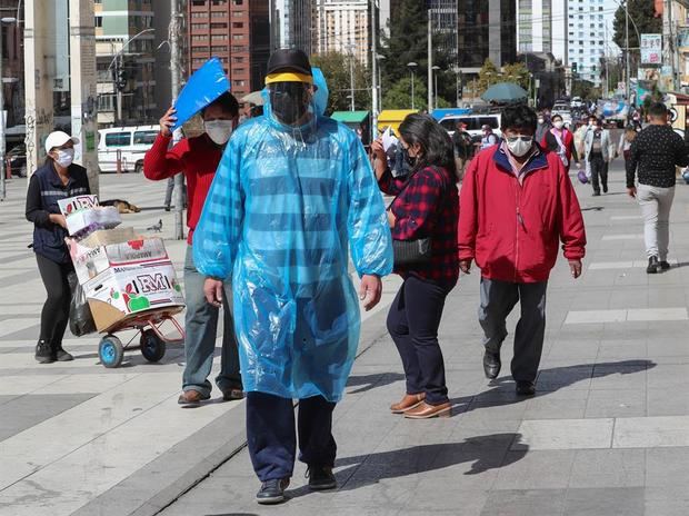 Un hombre camina con una bolsa, tapabocas y careta como medida de protección contra el coronavirus, el pasado 01 de junio del 2020, por las calles de La Paz, Bolivia.