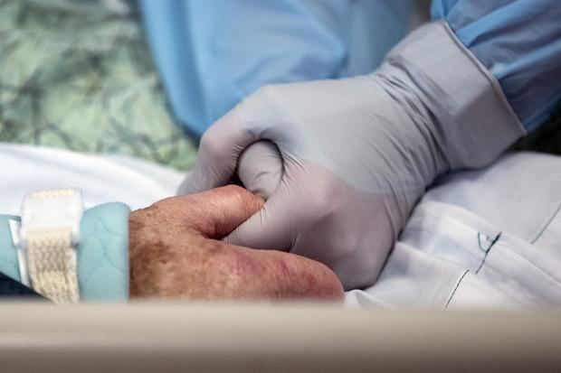 Imagen de archivo donde se ve a una enfermera que coge la mano de una paciente con coronavirus ingresada en la UCI de un hospital en La Mesa, EE.UU.
