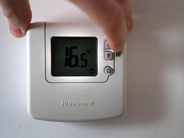 Un hombre ajusta la temperatura en un termostato en una casa en Londres.