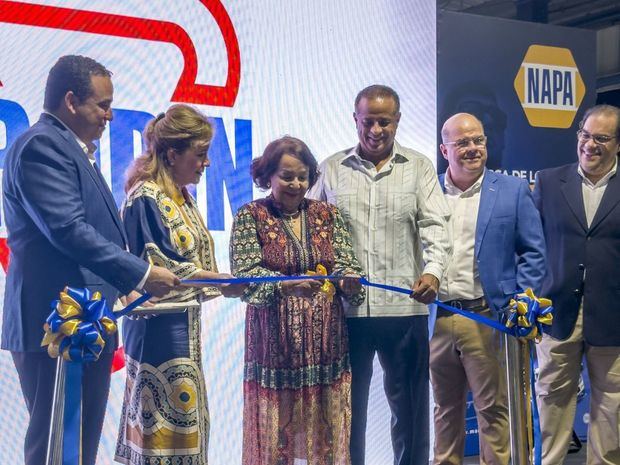 En el centro, doña Camelia Rodríguez viuda de Ureña, fundadora del Grupo MAU, corta la cinta inaugural. Le acompañan, desde la izquierda, Juan Manuel Ureña, presidente del Grupo MAU; Carmen Guerly Ureña y Junior Ureña, ejecutivos de esta empresa; Yenem Cordero, gerente general y Pedro Bisonó, administrador de la nueva sucursal.