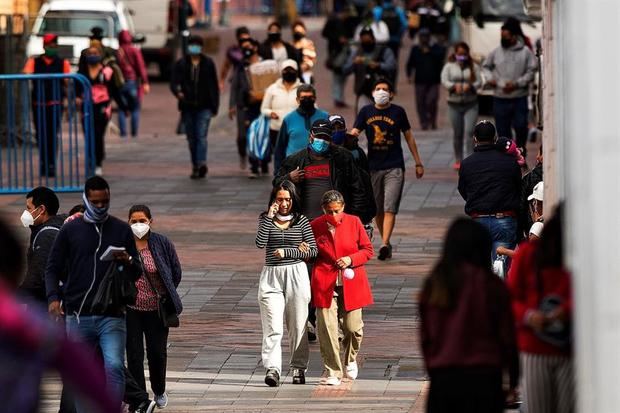Personas con mascarillas, para evitar la propagación del nuevo coroanavirus, fueron registradas este jueves, en una calle de Quito, Ecuador.