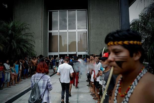 Indígenas de la etnia Guaraní se reúnen hoy, frente a la sede de la Fiscalía en Sao Paulo (Brasil) para protestar en contra de la decisión del presidente brasileño, Jair Bolsonaro, de encargar al Ministerio de Agricultura la demarcación de nuevas reservas indígenas. 
