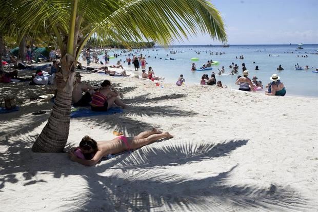 Turistas disfrutan de la playa en la isla de Roatán, en el caribe de Honduras. 