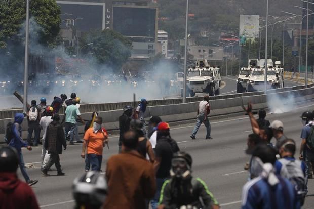 Simpatizantes del presidente de la Asamblea Nacional, Juan Guaidó, se enfrentan a las fuerzas oficialistas de las Fuerzas Armadas Bolivarianas (i), durante una manifestación en apoyo a su levantamiento contra el gobierno de Nicolás Maduro este martes, en Caracas.