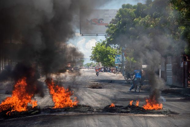 Manifestantes colocan una barricada durante protestas en una calle de la capital. Puerto Príncipe y varias capitales provinciales de Haití vivieron este martes la segunda jornada seguida de protestas contra la escasez de combustible, una serie de manifestaciones en las que ya se ha registrado un muerto. 