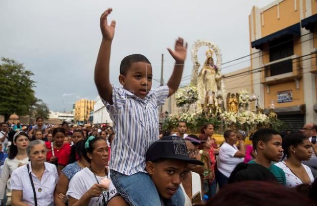 Un niño fue registrado este mates al levantar los brazos, durante la procesión de la Virgen de las Mercedes, patrona del país, en Santo Domingo (República Dominicana)
