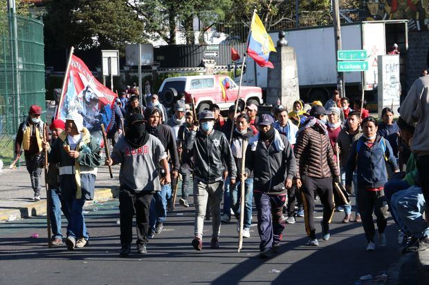 Un grupo de personas marcha este miércoles por una calle de Quito (Ecuador).