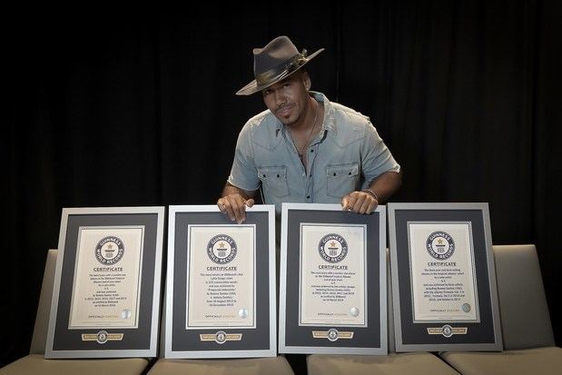 Fotografía sin fecha cedida por Guinness World Records donde aparece el cantante y compositor neoyorquino, Romeo Santos, mientras posa con sus cuatro certificados de récord mundial.
