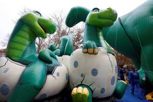 Los trabajadores de globos de Macy's trabajan en el globo 'Dino' un día antes del 93 ° Desfile Anual de Acción de Gracias de Macy's en Nueva York,  EE. UU.