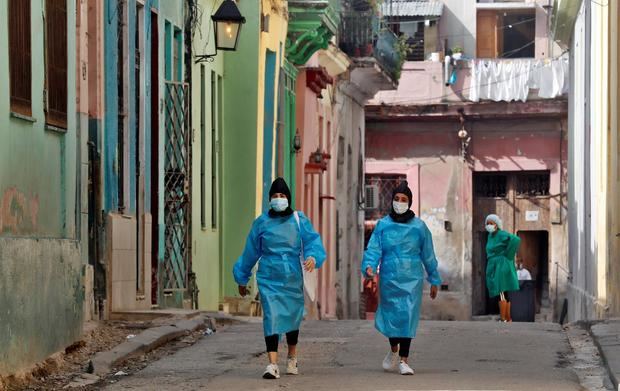 Trabajadoras de la salud caminan por una calle en La Habana, Cuba.