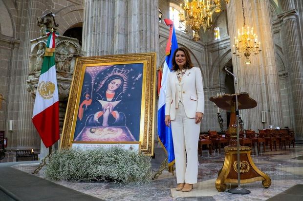 La Embajadora María Isabel Castillo Báez posa junto al retrato de la Virgen de la Altagracia.