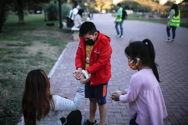 Niños juegan con mascarilla en un parque de Buenos Aires, Argentina.
