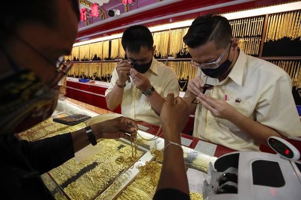 Tasadores de oro en una tienda de Bangkok. 