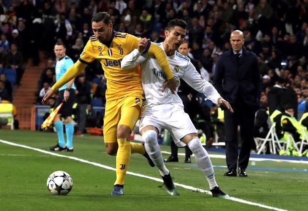El defensa italiano de la Juventus, Mattia De Sciglio (i), pelea un balón con el delantero portugués del Real Madrid, Cristiano Ronaldo (d), durante el partido de vuelta de cuartos de final de la Liga de Campeones que Real Madrid y Juventus jugaron el 11 de abril de 2018 en el estadio Santiago Bernabéu, en Madrid.