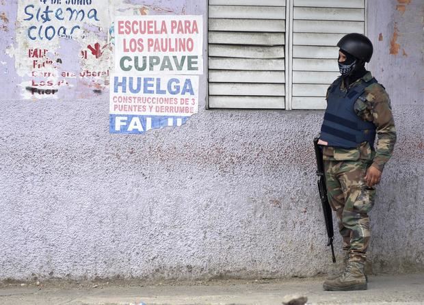 Un soldado vigila los al rededores donde se presenta un paro convocado en protesta por las políticas económicas del Gobierno, hoy, en Licey, República Dominicana.