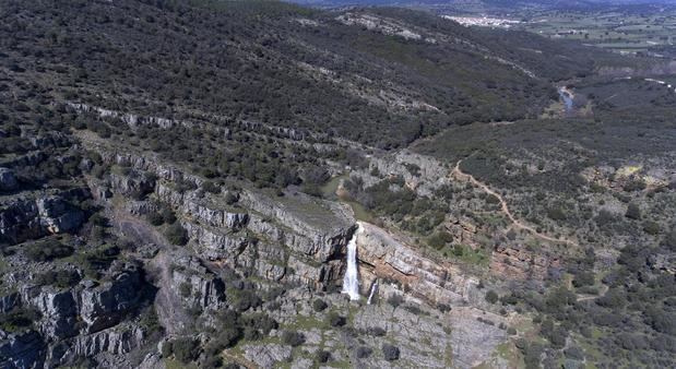 Vista aérea de la Cascada de la Cimbarra, con la población de Aldeaquemada (Jaén) al fondo, un pequeño paraíso oculto en el corazón de Sierra Morena. 