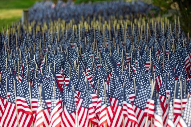 Más de 8.000 banderas, situadas en el patio de Mike Labbe en Grafton, rinden homenaje a las muertes de Covid -19 en Massachusetts, EE.UU.