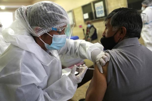 Un hombre es vacunado en la Universidad Mayor de San Andrés, en La Paz.
