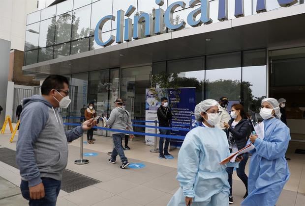 Personal de seguridad evita que se tomen fotografías en los exteriores de una clínica privada, este jueves en Lima, Perú.