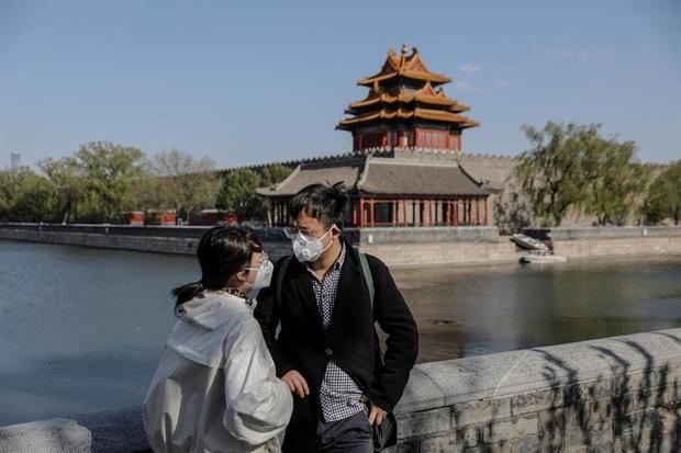 Una pareja con mascarillas visitan una zona próxima a la Ciudad Prohibida en Pekín, China.