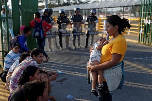 Policía mexicana resguarda la entrada del frontera hacia México en el puente Rodolfo Robles que divide el país con Guatemala, para evitar que migrantes hondureños, de la nueva caravana de migrantes, ingrese sin pasar el registro exigido por el Gobierno, este sábado, en Tecún Umán, Guatemala. 