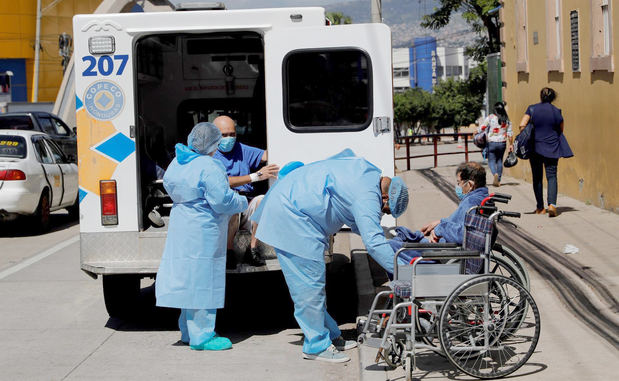 Personal médica atiende a dos hombres con sospechas de padecer covid-19, afuera del Hospital San Felipe hoy, en Tegucigalpa, Honduras.