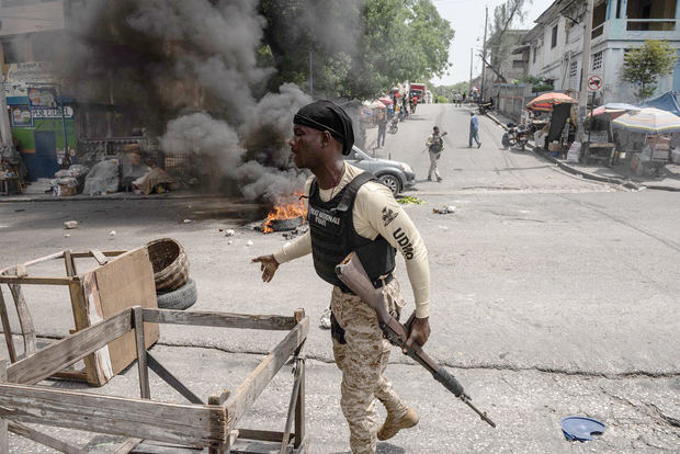 Policías recogen llantas de las barricadas durante una protesta de ciudadanos para rechazar la inseguridad y los constantes secuestros en Puerto Príncipe (Haití), en una fotografía de archivo.