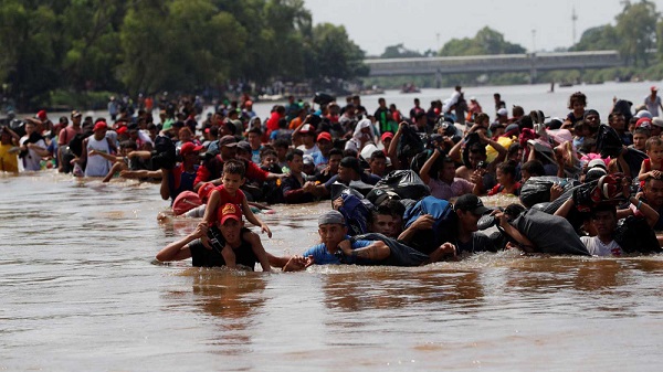 Migrantes cruzando el río