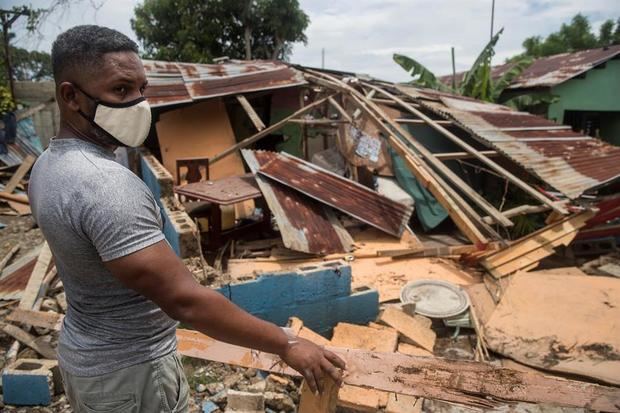Un hombre intenta reparar su vivienda dañada por el paso del huracán Isaías, este viernes en Hato Mayor (República Dominicana).