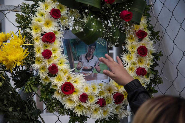 Médicos colegas de Óscar Hernández, de 45 años quien murió hoy por coronavirus, colocan flores y fotos en la entrada del hospital del Parque de la Industria, en Ciudad de Guatemala. 