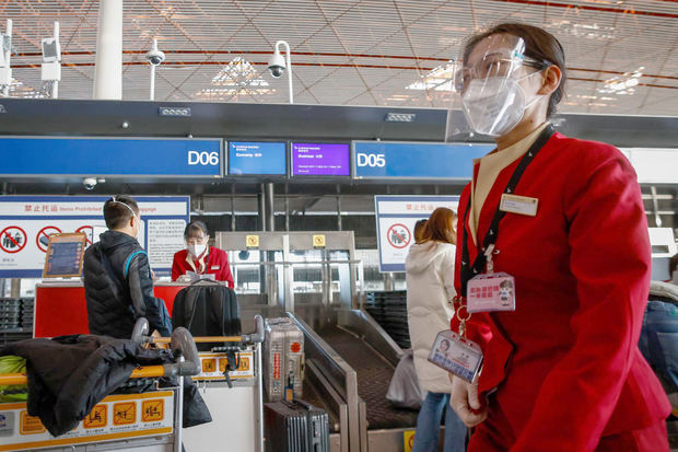 Personal de las líneas aéreas atiende a los pasajeros en el Aeropuerto Internacional de Pekín el 30 de noviembre de 2022.