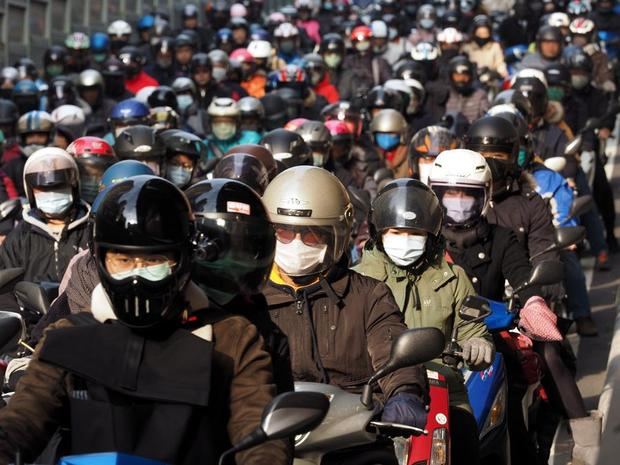 Motoristas taiwaneses conducen con máscaras faciales en Taipei, Taiwán.