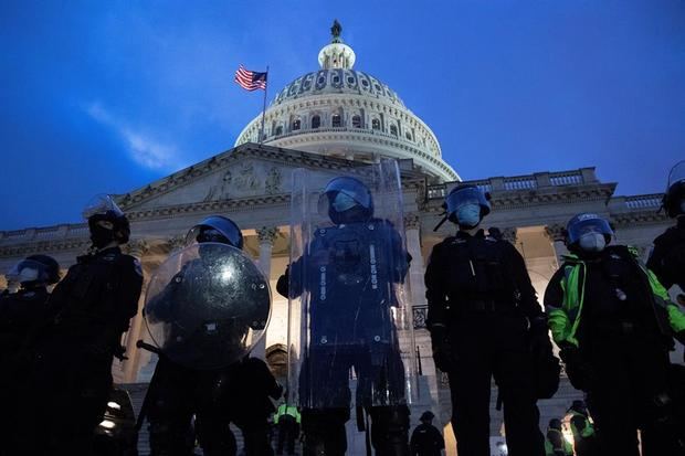 Agentes antidisturbios custodian la entrada del Capitolio de EE.UU. tras desalojar a los cientos de seguidores del presidente Donald Trumpque irrumpieran en él por la fuerza.