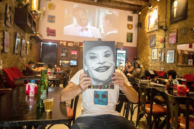 Un hombre sostiene el menú con la foto del personaje Joker en el bar Cine Botequin, el 5 de octubre de 2021, en Río de Janeiro, Brasil.