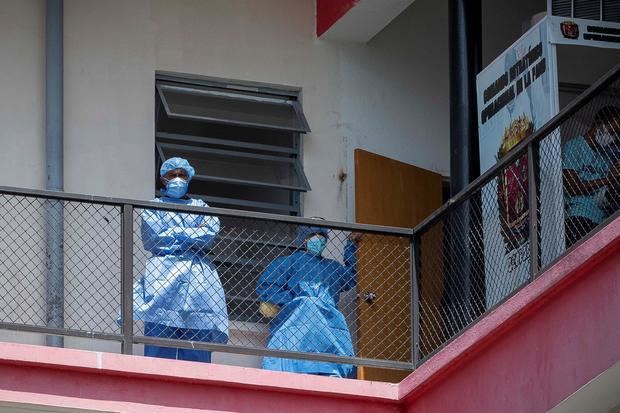 Dos trabajadores de la salud permanecen en un balcón del Hospital Universitario de Caracas, en Caracas, Venezuela.
