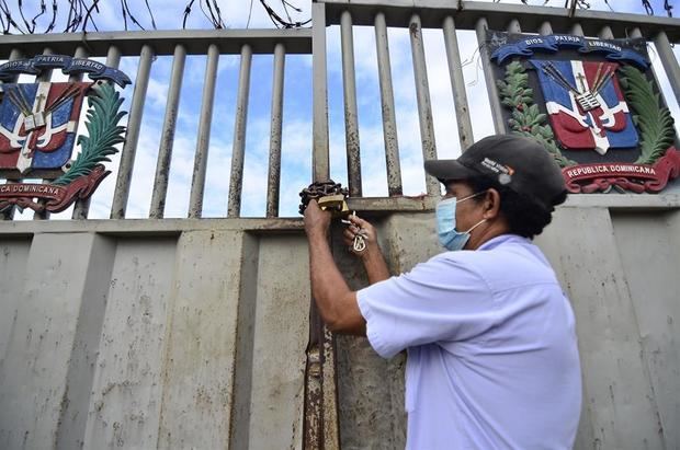 Un funcionario dominicano de migración abre el portón fronterizo hoy, durante la reapertura del tradicional mercado binacional de la ciudad fronteriza de Dajabón, República Dominicana.