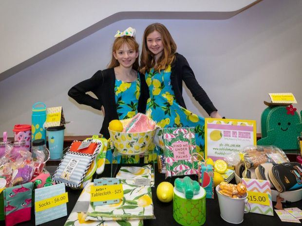 Hailey Hertzman (izda.) y Katie Vonder Haar muestran algunos de los productos en venta de su negocio “Ooh La Lemon”. (© Lemonade Day)