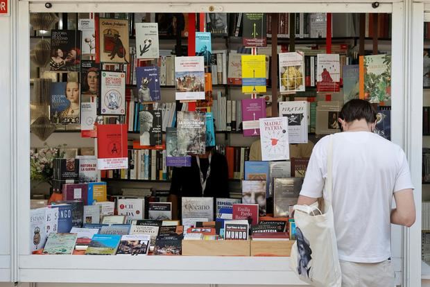 Un hombre se intersa por un libro en la Feria del Libro de Madrid que hoy ha sido inaugurada por la reina Letizia en el Parque del Retiro de la capital.