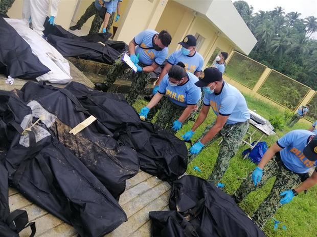 Foto distribuida por la Estación de Policía de Matalom de la Policía Nacional de Filipinas (PNP) muestra a los policías identificando a las víctimas de deslizamientos de tierra en Baybay, provincia de Leyte, Filipinas, tras el paso de la tormenta tropical Megi.