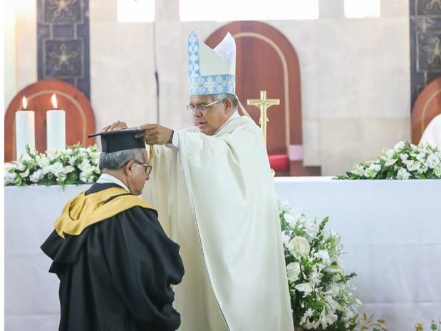 Monseñor Francisco Ozoria Acosta, Gran Canciller de la Universidad procedió a colocar los atributos académicos al nuevo rector: Monseñor Ramón Benito Ángeles Fernández.