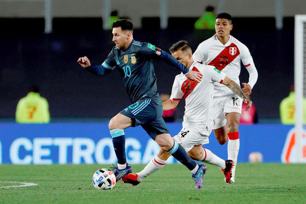Lionel Messi (i) de Argentina disputa hoy el balón con Gabriel Costa de Perú, durante un partido por las eliminatorias sudamericanas al Mundial de Catar 2022, en el estadio Monumental en Buenos Aires, Argentina.