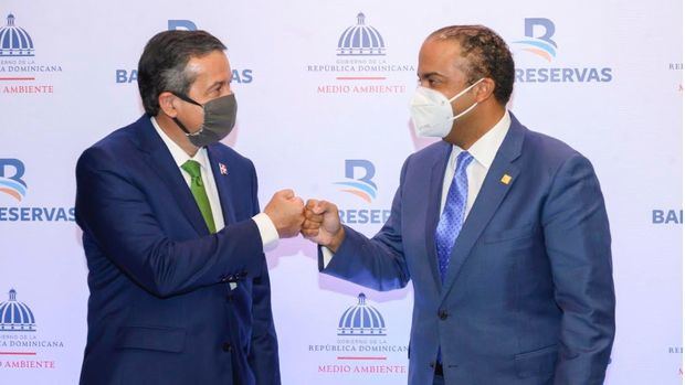 El ministro de Medio Ambiente, Orlando Jorge Mera; y el administrador general de Banreservas, Samuel Pereyra, se saludan luego de firmar un acuerdo para la preservación del manatíes antillanos.
